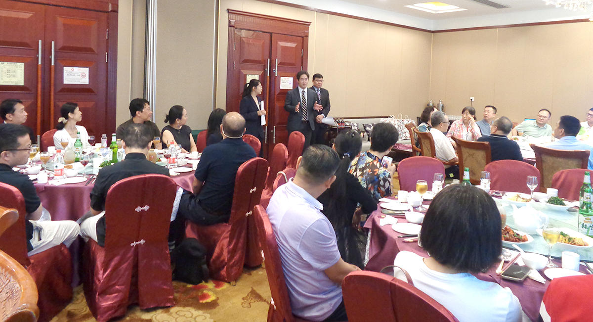 同窓会で挨拶する高木常務